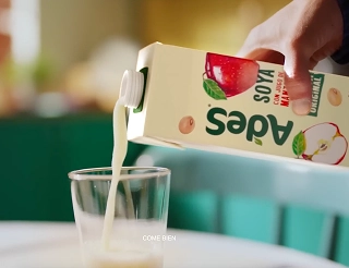 Primer plano de un vaso recibiendo bebida de soya AdeS, ejemplificando la expansión del portafolio multicategoría para refrescar todas las ocasiones de consumo.